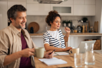 Relaxed Business Meeting Between Colleagues In A Modern Home Kitchen With Laptop And Coffee