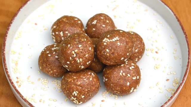 Makar Sankranti special til gud laddu in a white plate. highlights homemade food, traditional recipes, and healthy natural ingredients