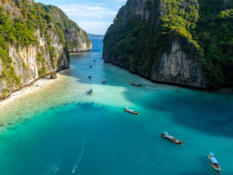 Aerial view of turquoise waters meet the towering cliffs, boats dotting the serene landscape, a paradise unveiled, Tambon Ao Nang, Chang Wat Krabi, Thailand.