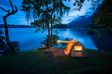 Night camping adventure with a cozy tent lit under the starry sky in a summer forest