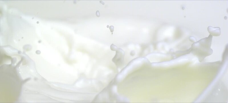Slow motion almonds falling into milk. Milky splash