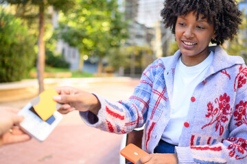 Young woman making contactless payment with credit card