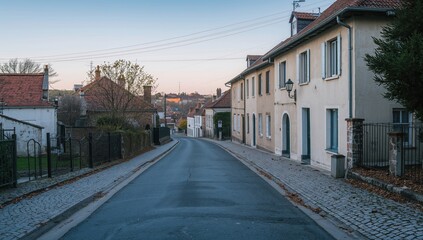 Fototapeta premium Peaceful neighborhood street with houses and sidewalks under soft light