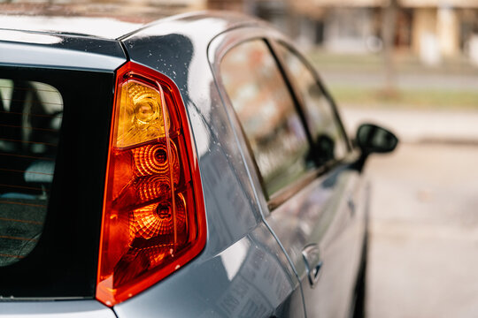 Close-up of rear car taillight in focus during vehicle cleaning process