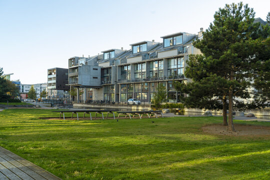 View of modern architecture meets nature's tranquility with lush green grass contrasting against the building's facade, Vastra Hamnen, Malmo, Sweden.