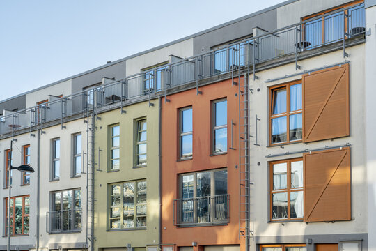 View of colorful buildings stand side-by-side, each with unique windows and balconies, reflecting the clear sky above, Vastra Hamnen, Malmo, Sweden.