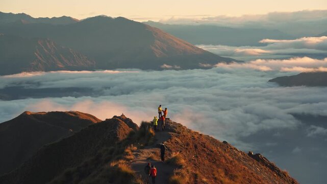 Couple proposing marriage on Roys Peak above foggy mountain at sunrise