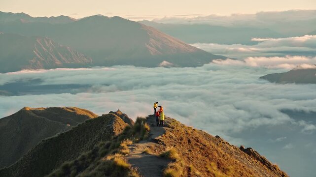 Couple proposing marriage on Roys Peak above foggy mountain at sunrise