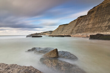 Obraz premium Cliffs on Magoito beach, Sintra, Portugal. Geological phenomena of interest. Extensive sandy area.