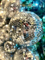 Shimmering disco balls of various sizes, reflecting light in a vibrant arrangement, creating a festive atmosphere for celebrations and events. Christmas vertical background