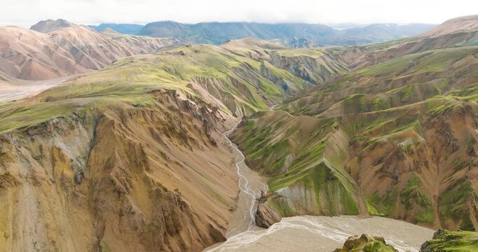 Aerial view of majestic Landmannalaugar mountains, a symphony of textures where ochre slopes meet vibrant green valleys, Iceland's raw beauty, Landmannalaugar, Iceland.
