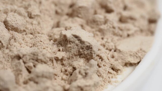 Protein powder in a measuring spoon. Bodybuilding, fitness and lifestyle in the gym. The concept of sports, health and nutrition	
