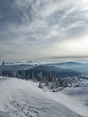 Frosted mountain landscape with layered hills and cloudy sky