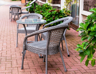 charming outdoor cafe terrace with wicker seating surrounded by lush plants invites travelers to relax