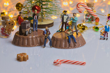Creative ho scale miniature christmas scenes, santa claus, musicians, and families in a giant candy miniature christmas band playing holiday music