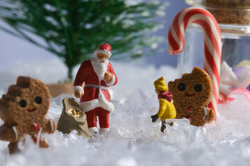 Creative ho scale miniature christmas scenes, santa claus, musicians, and families in a giant candy miniature santa claus with gingerbread man in winter wonderland