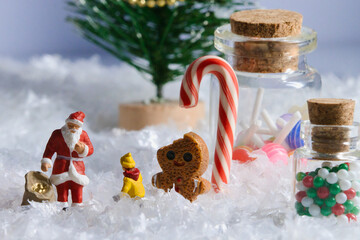 Creative ho scale miniature christmas scenes, santa claus, musicians, and families in a giant candy miniature santa claus standing with gingerbread man and treats