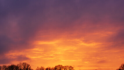 Beautiful sunset sky with vibrant orange glow and purple clouds