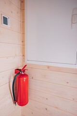 A Functional Fire Extinguisher Mounted on a Wooden Wall, Demonstrating Safety and Readiness in Emergency Preparedness within Indoor Spaces