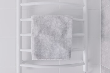 White Towel Draped Elegantly Over a Modern Towel Warmer in a Bright and Minimalistic Bathroom Setting