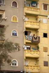 Rugs hanging from the balcony of a high rise apartment building across from the Catacombs of Kos el Shoqafa in Alexandria, Egypt