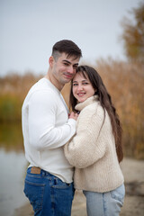 Fototapeta premium A happy young couple is walking on the river bank