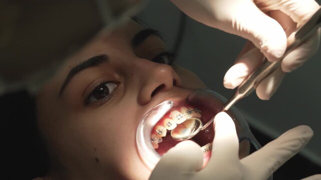 Orthodontist checking patient's dental braces