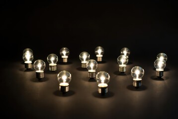 Array of illuminated miniature light bulbs glowing on a surface, symbolizing innovation and bright ideas.