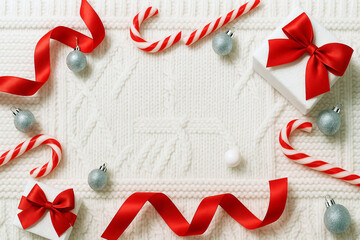 Christmas Flat Lay with Red Ribbons and Candy Canes on White Knitted Background