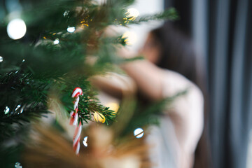 Blurred unidentifiable child near Christmas tree expressing abstract joy, anonymous holiday atmosphere concept