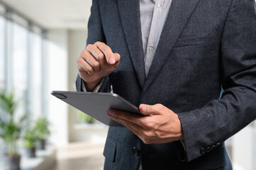 Businessman Using Tablet in Modern Office Environment for Work