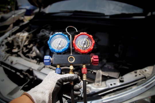 Mechanic Checking Car AC Refrigerant with Manifold Gauge Set
