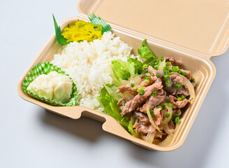 Delicious takeout food in eco-friendly container with rice and meat