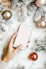 Smartphone with empty display in hand on Christmas white decorations background.