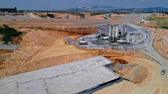 Drone aerial view of a large highway interchange construction site with bridges, underpasses and road platforms. Major infrastructure and civil engineering project under development.