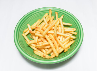 Delicious golden French fries on a vibrant green plate
