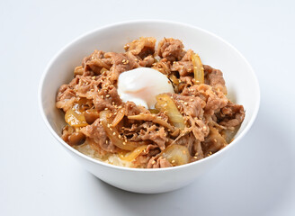 Savory Japanese Gyudon beef bowl topped with a perfectly cooked onsen egg and sesame seeds ready to eat