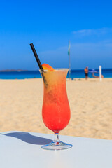 Sex on the beach cocktail on beautiful sunny sand beach background