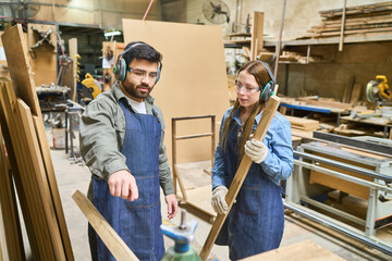 Fototapeta premium Young apprentice and mentor collaborating in a lumber workshop