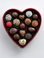 Obraz premium Assortment of gourmet chocolate truffles in a red heartshaped box