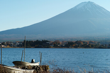Boats floating on the water at the port with Fuji mountain isolated on blue sky in background