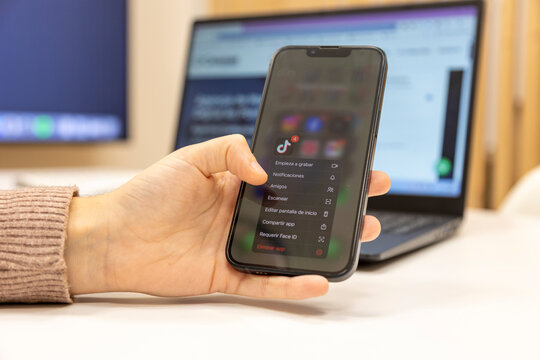Hand using smartphone for uninstalling tiktok app