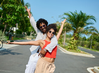 Portrait of a young couple at the beac in summertime,  a man and a woman are playing with a blue...