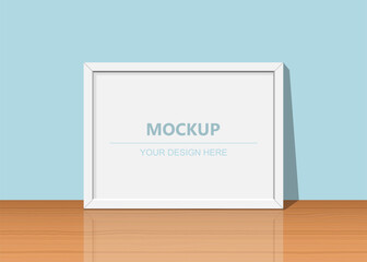 Blank frame mockup on wooden surface © GRAPHIC ZONE