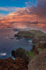 Rugged basalt cliffs and sea stacks meet turquoise surf at Ponta de Sao Lourenco, Madeira, Portugal. Warm low light and storm clouds cast a moody end of island feel.