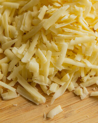 Grated Cheese on Wooden Cutting Board