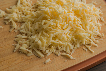 Grated Cheese on Wooden Cutting Board