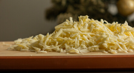 Grated Cheese on Wooden Cutting Board