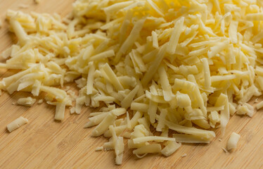 Grated Cheese on Wooden Cutting Board