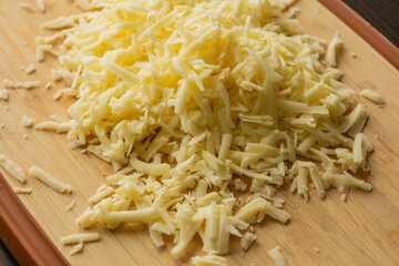 Grated Cheese on Wooden Cutting Board